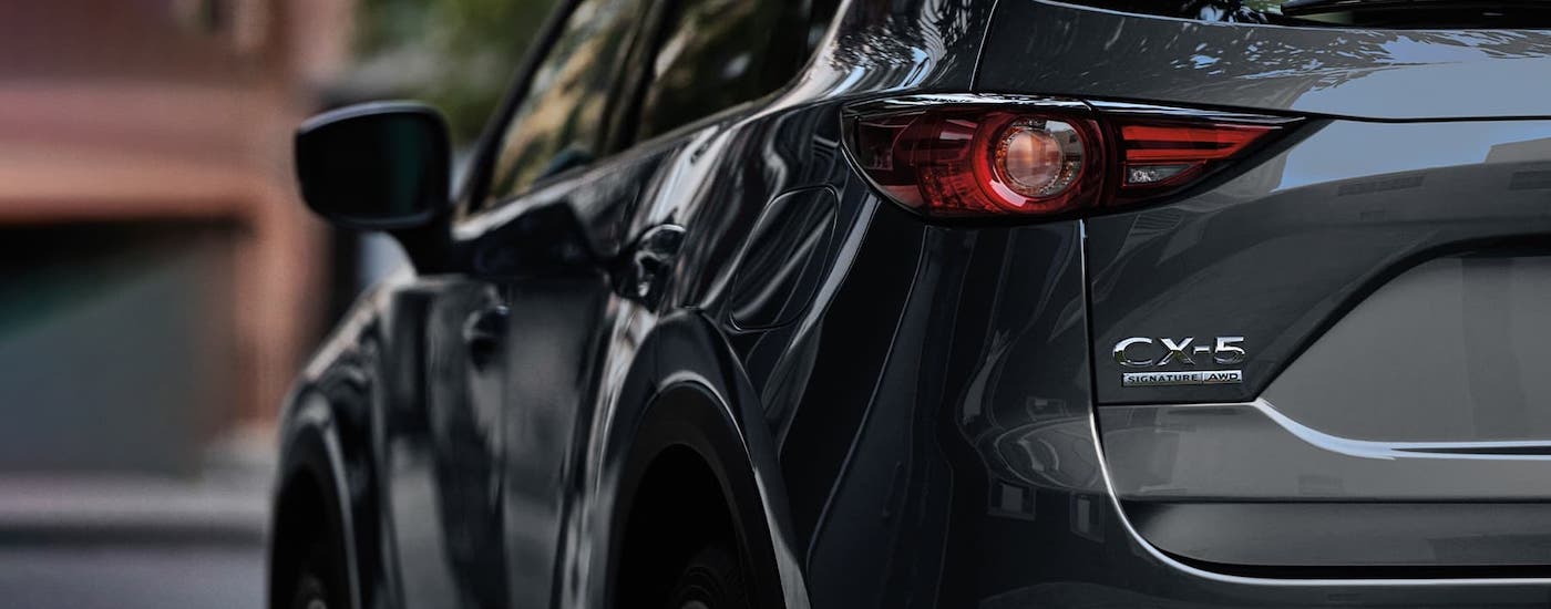 A closeup shows the rear badging of a gray 2021 Mazda CX-5.