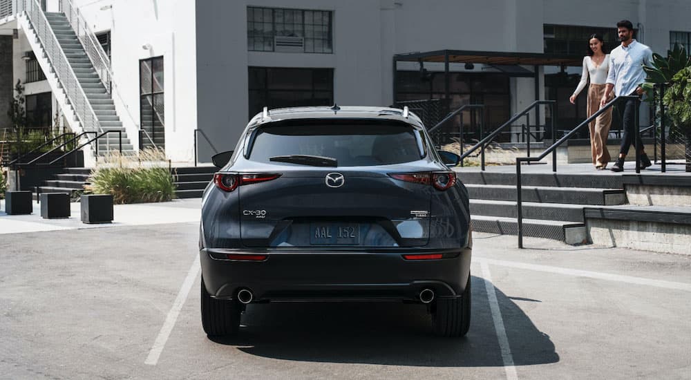 A grey 2022 Mazda CX-30 is shown from the rear parked in front of stairs.
