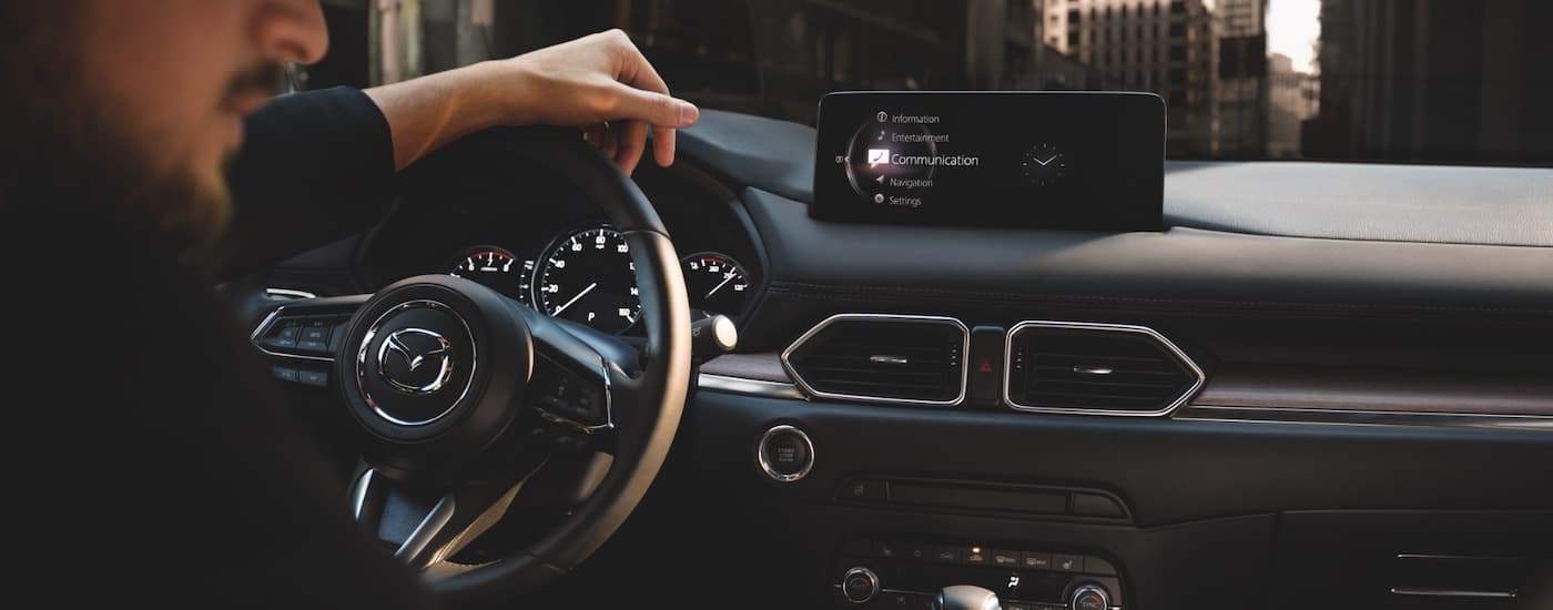 A close up shows the infotainment screen and passanger in a 2021 Mazda CX-5.